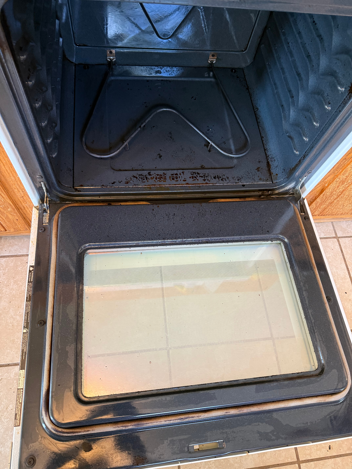 The same oven door cleaned to clear glass and bare metal