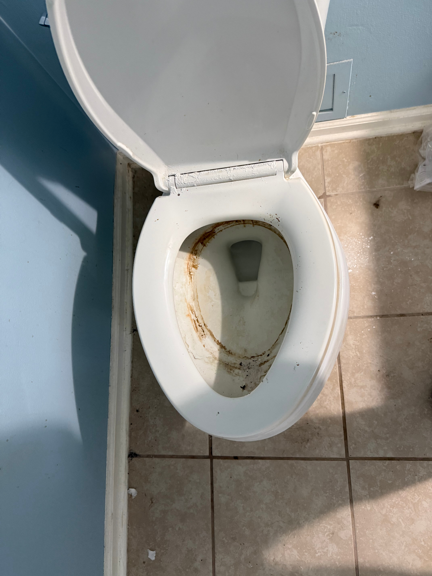 Toilet bowl with heavy rust rings and staining around the rim